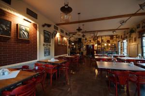 a restaurant with wooden tables and red chairs at Prohibicja Peter's Pub in Mikołajki