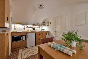 een keuken met een houten tafel en een keuken met een koelkast bij Apartment Center in Kamnik