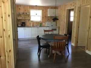 a kitchen and dining room with a table and chairs at Chalet Les Parulines in Tadoussac