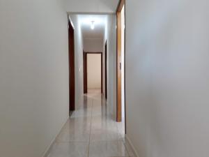 a hallway with white walls and a tile floor at Casa Premiatto in Holambra