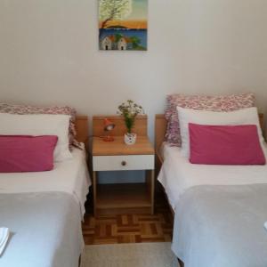 ein Zimmer mit 2 Betten und einem Nachttisch dazwischen in der Unterkunft Mendula Apartment in Rogač