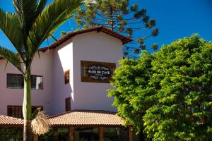 a white building with a sign on the side of it at Flor de Café Pousada in Pedra Menina