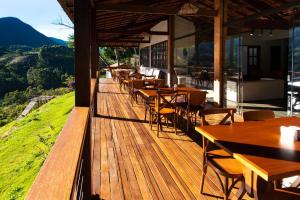 a restaurant with tables and chairs on a wooden deck at Flor de Café Pousada in Pedra Menina +23 photos