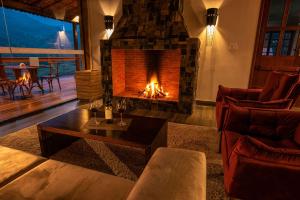 a living room with a fireplace and a couch at Flor de Café Pousada in Pedra Menina