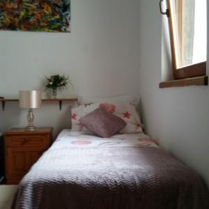 a bedroom with a bed with a pillow and a window at Mendula Apartment in Rogač