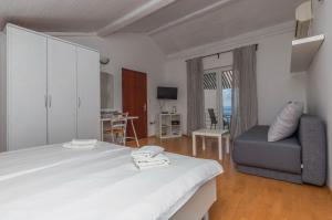 ein Schlafzimmer mit einem großen Bett und einem Stuhl in der Unterkunft Apartments Martina in Jadranovo