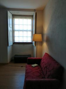a living room with a red couch and a window at Casa do Vale de Cerva in Cerva +61 photos