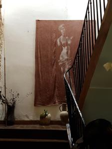 a staircase with a picture of a woman on the wall at Le Nid des Oiseaux in Cubjac