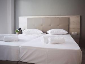 ネイポリにあるEnjoy Apartments & Studiosの白いベッド2台(白いシーツ、枕付)