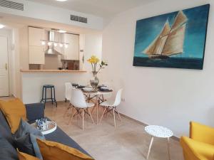 a living room with a table and a sailboat painting on the wall at Casaberian Manilva Beach Estepona, Marbella, Malaga, SPAIN in Manilva