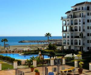 a building with a swimming pool next to a beach at Casaberian Manilva Beach Estepona, Marbella, Malaga, SPAIN in Manilva