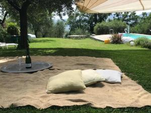 two pillows on a blanket on a table with a bottle of wine at La Casa nel Sole in Castelnuovo Magra