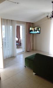 een slaapkamer met een bed en een televisie aan de muur bij YALÇINKAYA PANSİYON in Burhaniye