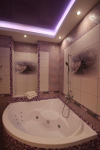 y baño con bañera y espejo. en Natali Luxury Apartments, en Voronezh