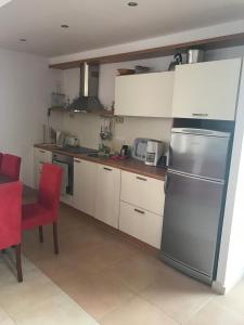 a kitchen with white cabinets and a stainless steel refrigerator at Sun Village Villa 13 in Byala