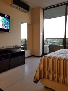 a bedroom with a bed and a flat screen tv at Condominio del alto 3 in Rosario
