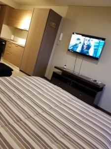 a hotel room with a bed and a flat screen tv at Condominio del alto 3 in Rosario