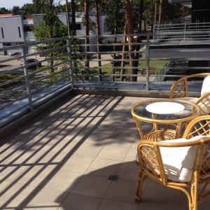 a patio with two chairs and a table on a balcony at Baltic Pogorzelica in Pogorzelica