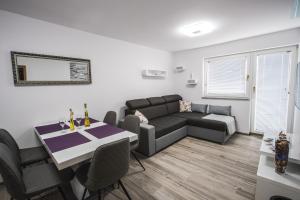 uma sala de estar com um sofá e uma mesa em Apartment Ma&Ja with Hot Tub em Metlika
