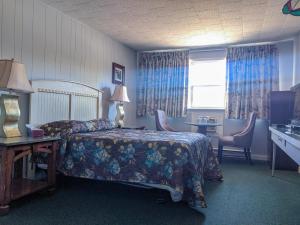 a woman sitting on a bed in a hotel room at Skyline Motel in Fredericton