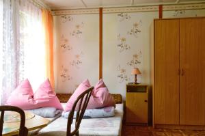 Habitación con almohadas rosas en una cama con ventana en Domki letniskowe U GOSI en Trzęsacz