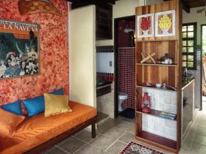a living room with an orange couch in a room at Pousada Casa Milà in Ubatuba +32 photos