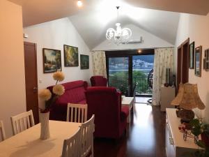 a living room with a red couch and a table at Apartments Dijana in Kotor