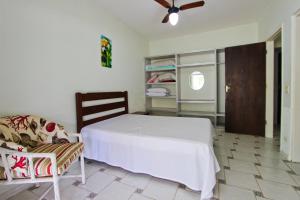 - une chambre avec un lit blanc et une chaise dans l'établissement CASA TEMPORADA TUCO E TUCA, à Ubatuba
