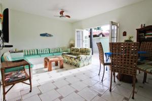 a living room with a couch and a chair at CASA TEMPORADA TUCO E TUCA in Ubatuba