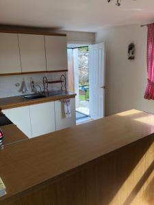a kitchen with white cabinets and a wooden counter top at Laurel Country Cottage in Ballymena