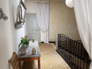 einen Flur mit einem Tisch und eine Treppe mit einer Tür in der Unterkunft Le Nid des Oiseaux in Cubjac