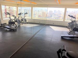 a gym with exercise bikes in a room with windows at Departamento Centro de Viña del Mar in Viña del Mar