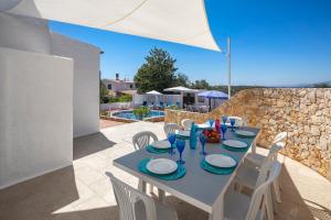 a table and chairs on the patio of a house at Villa Tara, Heated private pool, short walk to to town & beach in Carvoeiro