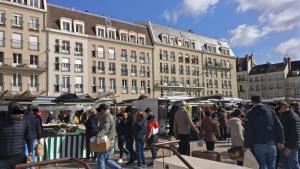 Une foule de gens se tenant autour d'un marché devant les bâtiments dans l'établissement Studio Royal by Beds4Wanderlust - Place du marché avec parking privé, à Fontainebleau
