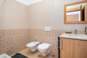 a bathroom with a toilet and a sink and a mirror at AL Cabanas de Tavira in Cabanas de Tavira +12 photos