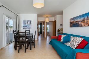 a living room with a blue couch and a table at AL Cabanas de Tavira in Cabanas de Tavira