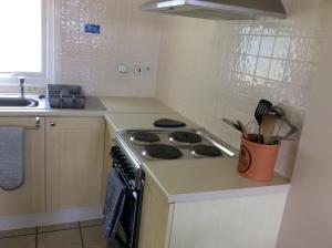 a kitchen with a stove and a sink at 19 Chalet Bucklands , Bideford Holiday Park. in Bucks Mills