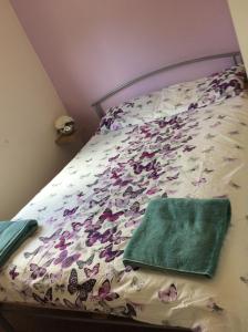 a bed with a bedspread with butterflies on it at 19 Chalet Bucklands , Bideford Holiday Park. in Bucks Mills