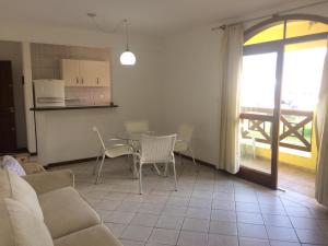 sala de estar con sofá, mesa y sillas en Apartamento em Residencial Riviera, en Florianópolis