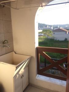 uma casa de banho com lavatório e uma janela com vista em Apartamento em Residencial Riviera em Florianópolis