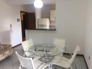comedor con mesa de cristal y sillas en Apartamento em Residencial Riviera, en Florianópolis