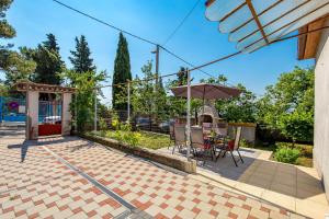 a patio with an umbrella and a table and chairs at Kantrida Home in Rijeka