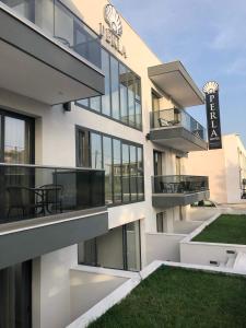 apartamentowiec z balkonem i trawnikiem w obiekcie Perla Hotel Halkidiki w mieście Kallithea