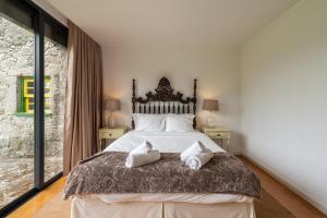 a bedroom with a large bed with two pillows on it at Eido Da Portela - Casa De Campo in Carregadouro
