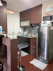 a kitchen with brown cabinets and a stainless steel refrigerator at Solano Hills-1 bedroom unit in Manila