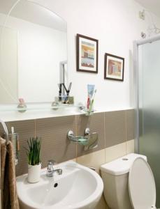 a bathroom with a sink and a toilet and a mirror at Solano Hills-1 bedroom unit in Manila