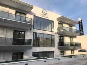 un edificio con un cartel en el costado en Perla Hotel Halkidiki, en Kallithea Halkidikis