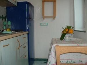 a kitchen with a table and a blue refrigerator at Il Giardino Dei Limoni in Ravello