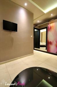 a room with a mirror and a tv on the wall at Louloudis Fresh-Adults Only in Skala Rachoniou