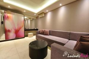 a living room with a couch and a large screen at Louloudis Fresh-Adults Only in Skala Rachoniou